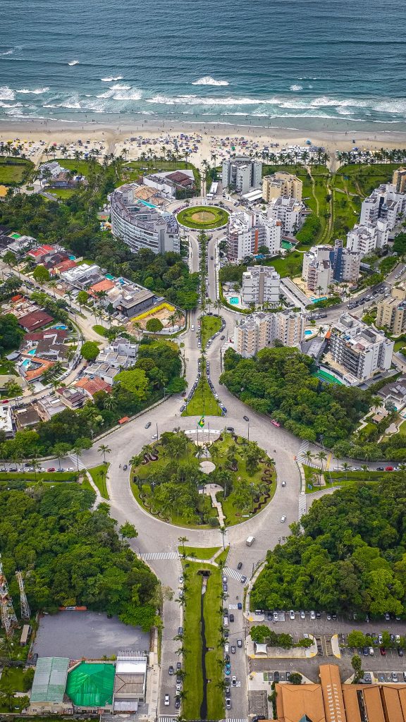 Stunning aerial view of a coastal city with lush greenery and unique roundabout architecture.